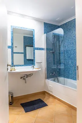 a bathroom with a sink and a tub and a mirror at Aldeia Azul Resort in Lagos