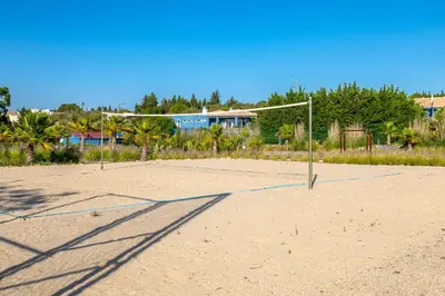 a volleyball court with a net in the sand at Aldeia Azul Resort in Lagos
