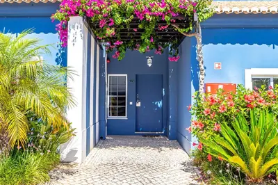 a blue house with flowers in front of it at Aldeia Azul Resort in Lagos