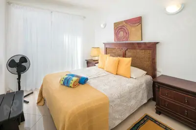 a bedroom with a bed and a fan at Maio Apartment in Luz