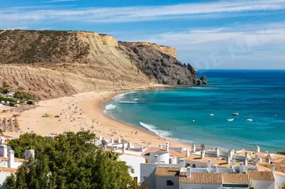 a view of a beach with buildings and the ocean at Maio Apartment in Luz