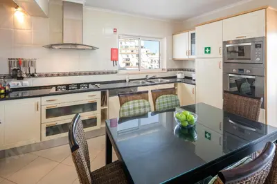 a kitchen with a table with chairs and a counter top at Maio Apartment in Luz