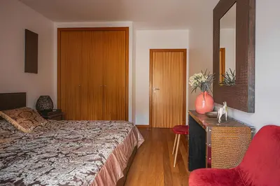 a bedroom with a bed and a red chair at Beachfront Penthouse with Panoramic Ocean-View Terrace VIP Baia in Machico