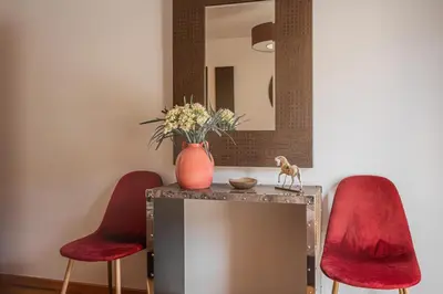 a table with two red chairs and a mirror at Beachfront Penthouse with Panoramic Ocean-View Terrace VIP Baia in Machico