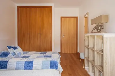 a bedroom with a bed with a blue and white blanket at Beachfront Penthouse with Panoramic Ocean-View Terrace VIP Baia in Machico