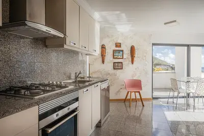a kitchen with a sink and a stove top oven at Beachfront Penthouse with Panoramic Ocean-View Terrace VIP Baia in Machico