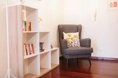 a chair in a room with a book shelf at Vip VI - Sea view apartment in Caniço