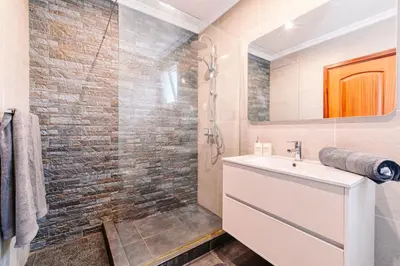 a bathroom with a sink and a brick wall at Vip VI - Sea view apartment in Caniço