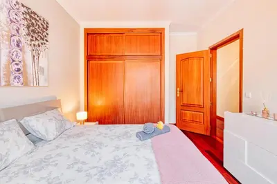 a bedroom with a bed and a wooden cabinet at Vip VI - Sea view apartment in Caniço