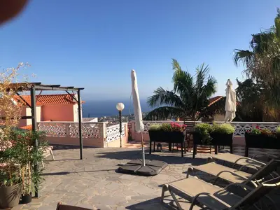a patio with a table and a swimming pool at Casa do Poço Funchal in Funchal