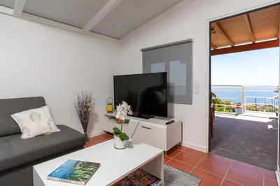 a living room with a couch and a flat screen tv at Apartment Annie 2 in Arco da Calheta