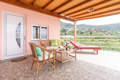 a patio with a couch and chairs on a deck at Apartment Annie 2 in Arco da Calheta