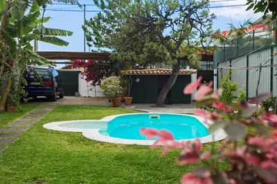 a small swimming pool in the yard of a house at Casa do Lugar de Baixo in Ponta do Sol
