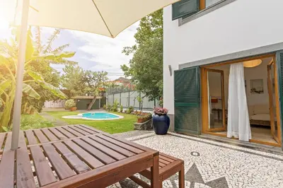 a patio with a wooden bench next to a house at Casa do Lugar de Baixo in Ponta do Sol