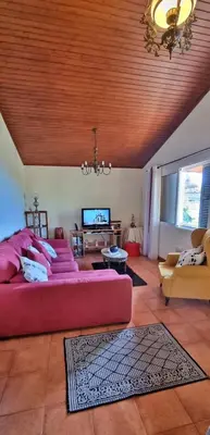 a living room with a red couch and two chairs at Villa Catanho in Funchal