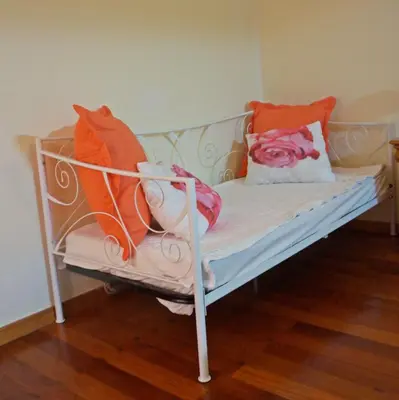 a bedroom with two beds and a chair and a mirror at Villa Catanho in Funchal