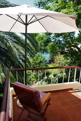 a balcony of a house with a table and chairs at Vila Calaça in Funchal