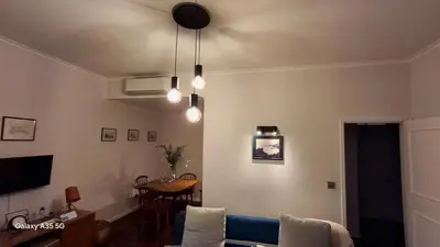 a living room with two blue couches and a large window at Vila Calaça in Funchal