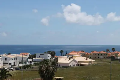 a bedroom with a bed and a large window at Villa dos Anjos in Porto Santo