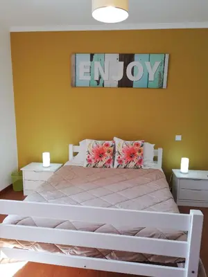 a bedroom with a white bed with flowers on it at FX Pena in Funchal