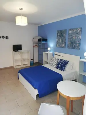 a blue bedroom with a bed and a table at FX Pena in Funchal