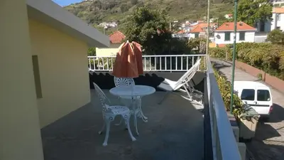 a patio with a table and chairs on a balcony at Apartamento Teixeira 2 in Arco da Calheta