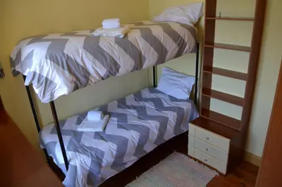 a bunk bed with towels on top of it at Hostel Casal São João in Ribeira Brava