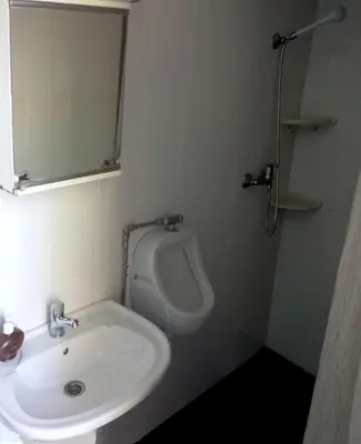 a bathroom with a sink and a urinal at Hostel Casal São João in Ribeira Brava