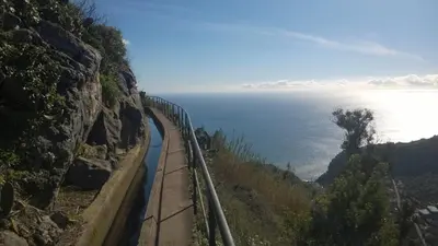 a train on a mountain next to the ocean at Hostel Casal São João in Ribeira Brava