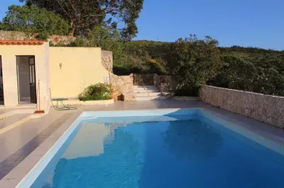 a large blue swimming pool in a yard at Villa Boa Vista Sul - Terra da Eira - Raposeira in Vila do Bispo