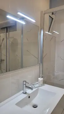 a bathroom with a white sink and a mirror at Sunhouse in Luz