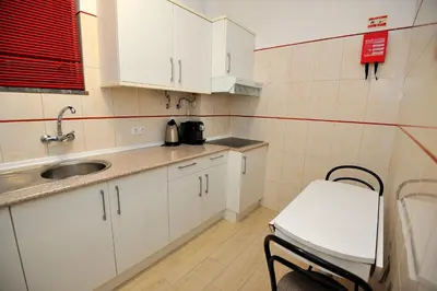 a small kitchen with white cabinets and a sink at Sunhouse in Luz