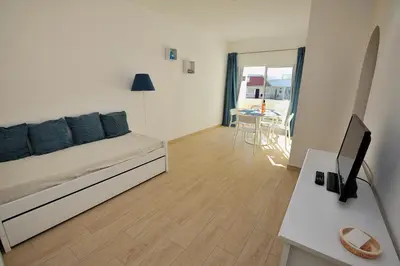 a room with a bed and a desk with a television at Sunhouse in Luz