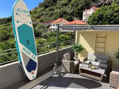 a surfboard sitting on the side of a balcony at Plaza Charming Flat in Santa Cruz