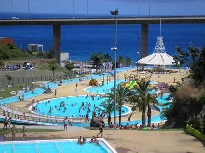 a large pool with people in it next to the ocean at Plaza Charming Flat in Santa Cruz