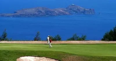 a man walking on a golf course near the water at Plaza Charming Flat in Santa Cruz