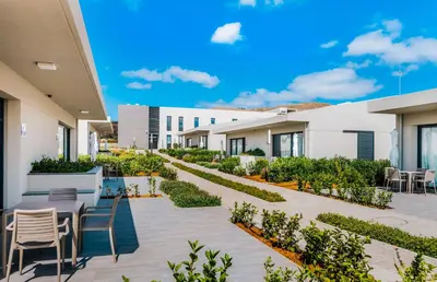 a courtyard with tables and chairs in a building at Vila Baleira Village in Porto Santo
