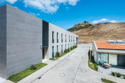 an exterior view of a building with mountains in the background at Vila Baleira Village in Porto Santo