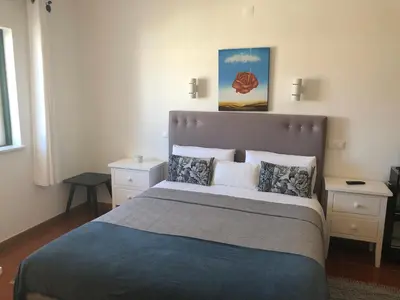 a bedroom with a large bed and two night stands at Casa GiGi in Sagres