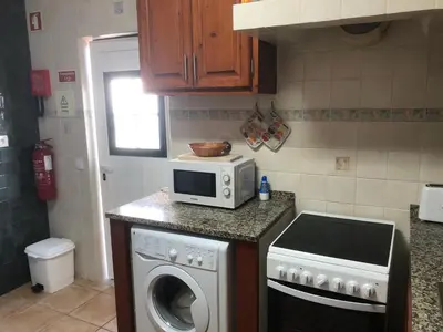 a kitchen with a washing machine and a microwave at Casa GiGi in Sagres