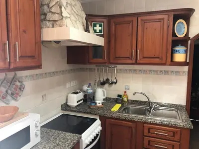 a kitchen with wooden cabinets and a sink at Casa GiGi in Sagres