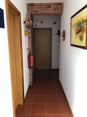 a hallway with a door and a brick wall at Casa GiGi in Sagres