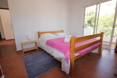 a bedroom with a bed and a large window at T3 Casa dos Arcos by Seewest in Salema