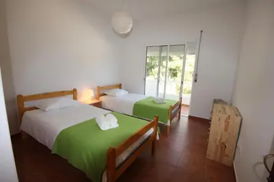 two beds in a room with a window at T3 Casa dos Arcos by Seewest in Salema