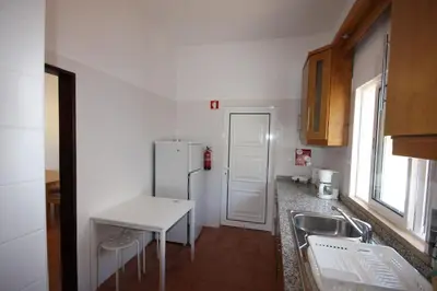 a small kitchen with a sink and a refrigerator at T2 Casa dos Arcos by Seewest in Salema