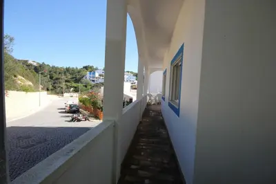 a hallway of a white building with a street at T2 Casa dos Arcos by Seewest in Salema