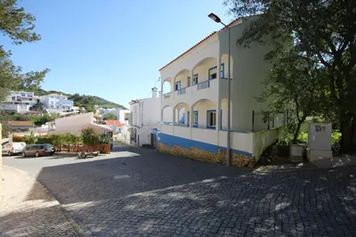 a building on the side of a street at T2 Casa dos Arcos by Seewest in Salema