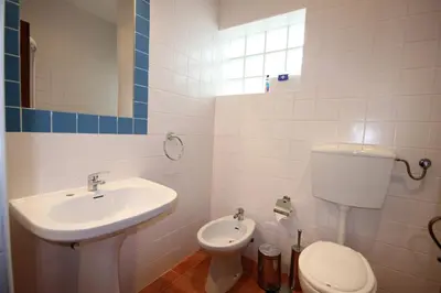 a white bathroom with a sink and a toilet at T2 Casa dos Arcos by Seewest in Salema