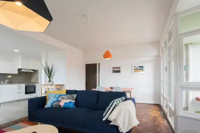 a living room with a blue couch and a kitchen at Elias Garcia II by An Island Apart in Funchal