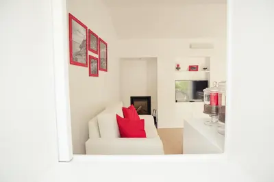 a living room with a white couch with red pillows at Vigia da Areia in São Lourenço